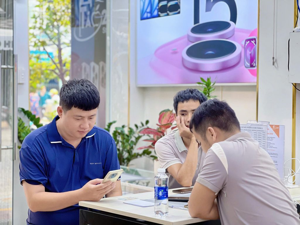 Khách hàng đang trải nghiệm iPhone cũ tại cửa hàng Táo 247 Đà Nẵng trước khi quyết định mua
