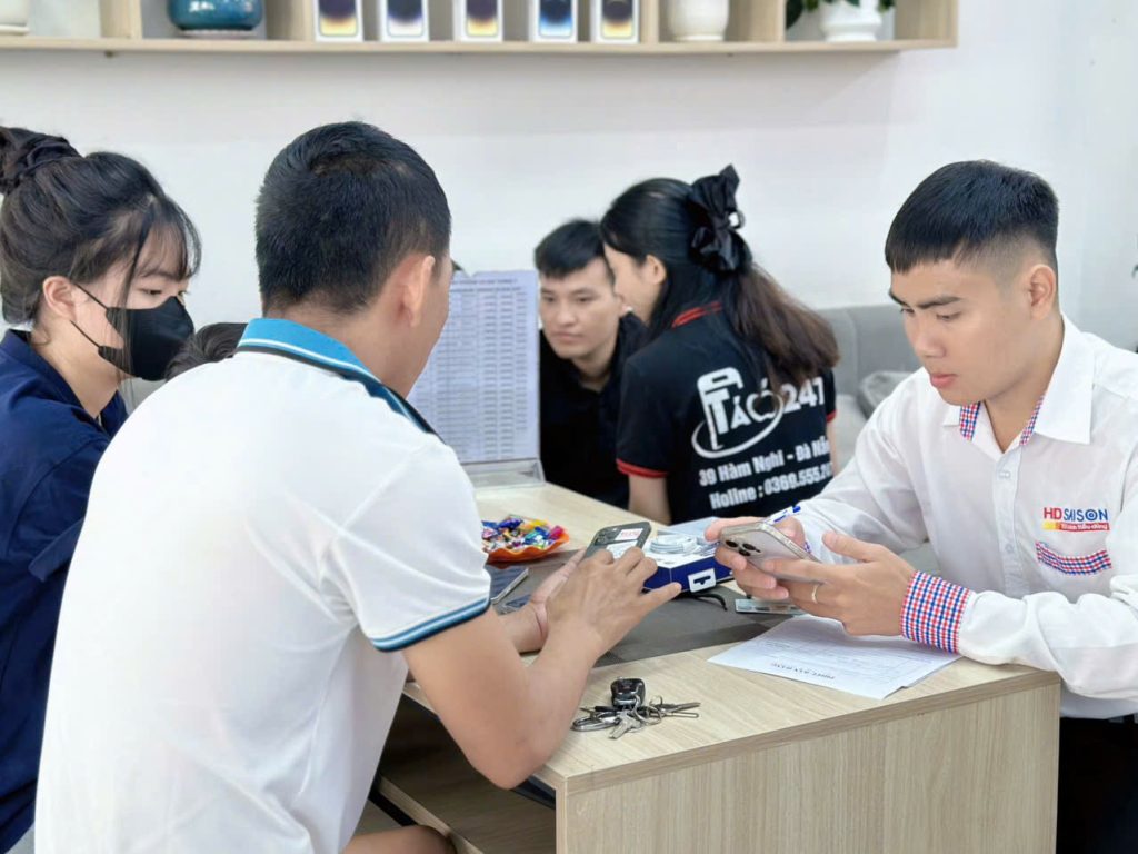 Khách hàng kiểm tra iPhone cũ tại Táo 247 Đà Nẵng cùng nhân viên tư vấn tận tâm
