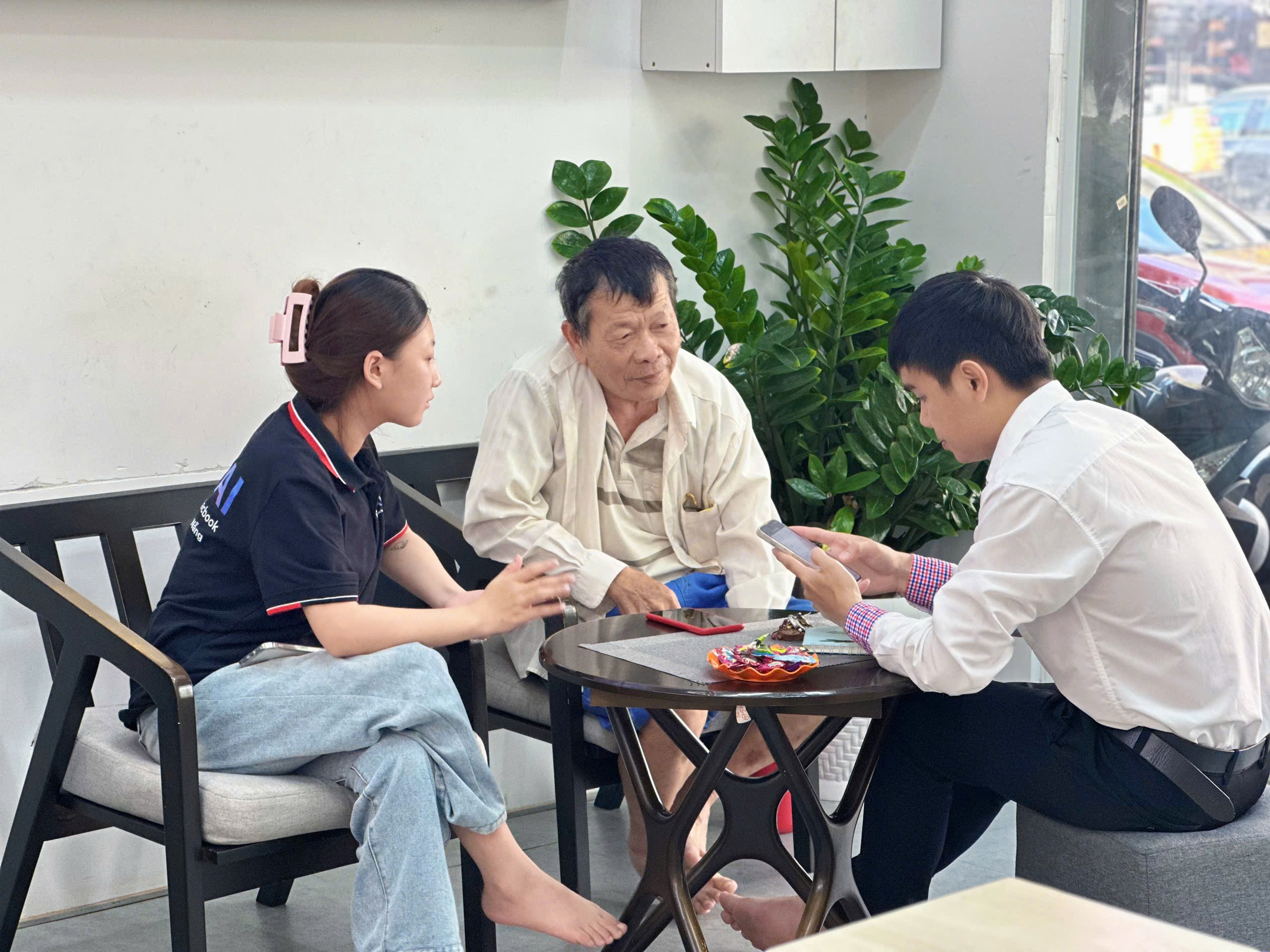 Nhân viên Táo 247 tư vấn mua iPhone 12 cũ cho khách hàng lớn tuổi tại cửa hàng Đà Nẵng