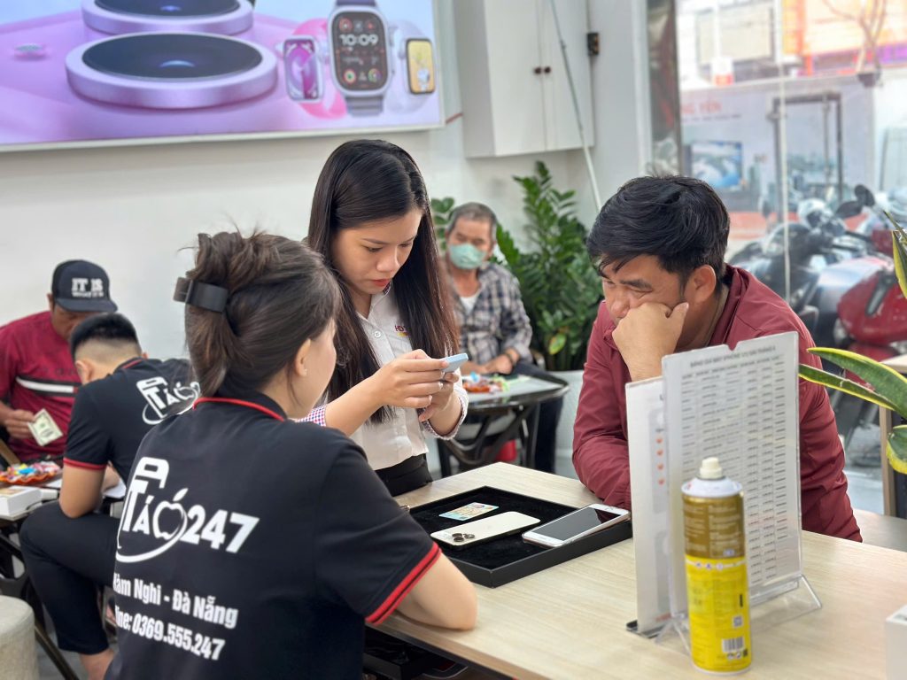 Khách hàng kiểm tra iPhone 11 cũ cùng nhân viên tại Táo 247 Đà Nẵng – đảm bảo minh bạch và rõ ràng trước khi mua
