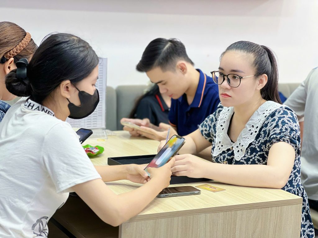 Khách hàng nữ được tư vấn mua iPhone 11 cũ tại Táo 247 Đà Nẵng – hỗ trợ kiểm tra máy trước khi mua
