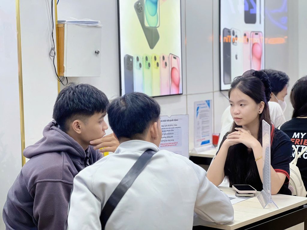 Nhân viên Táo 247 Đà Nẵng tư vấn thu cũ đổi mới iPhone cho khách hàng trẻ tại cửa hàng