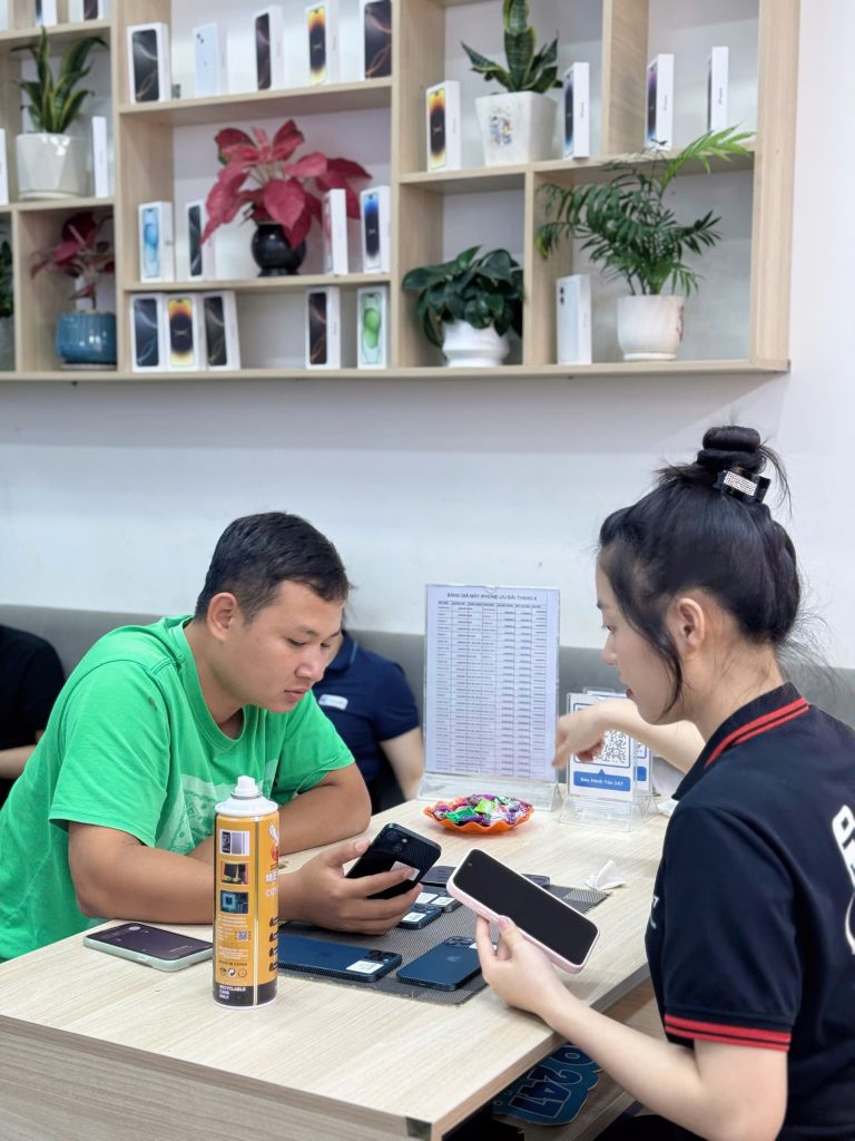 Khách hàng được nhân viên Táo 247 kiểm tra và hướng dẫn chọn iPhone cũ chính hãng tại Đà Nẵng