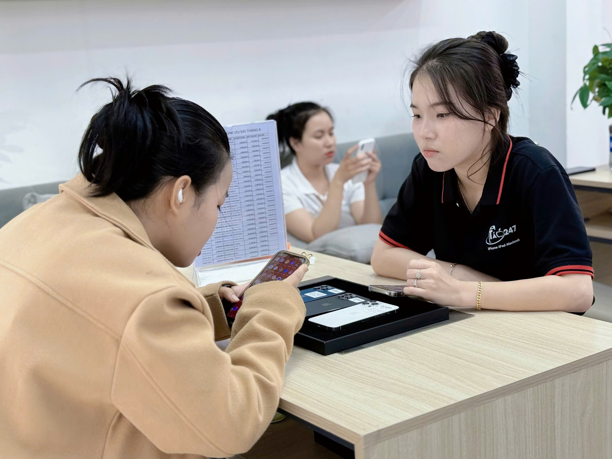 Khách hàng nữ trải nghiệm iPhone cũ tại cửa hàng Táo 247 Đà Nẵng cùng nhân viên hỗ trợ tận tình