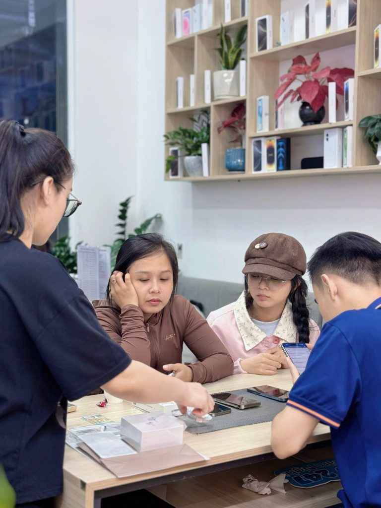 Khách hàng nữ đang được tư vấn mua iPhone cũ còn bảo hành tại Táo 247 Đà Nẵng
