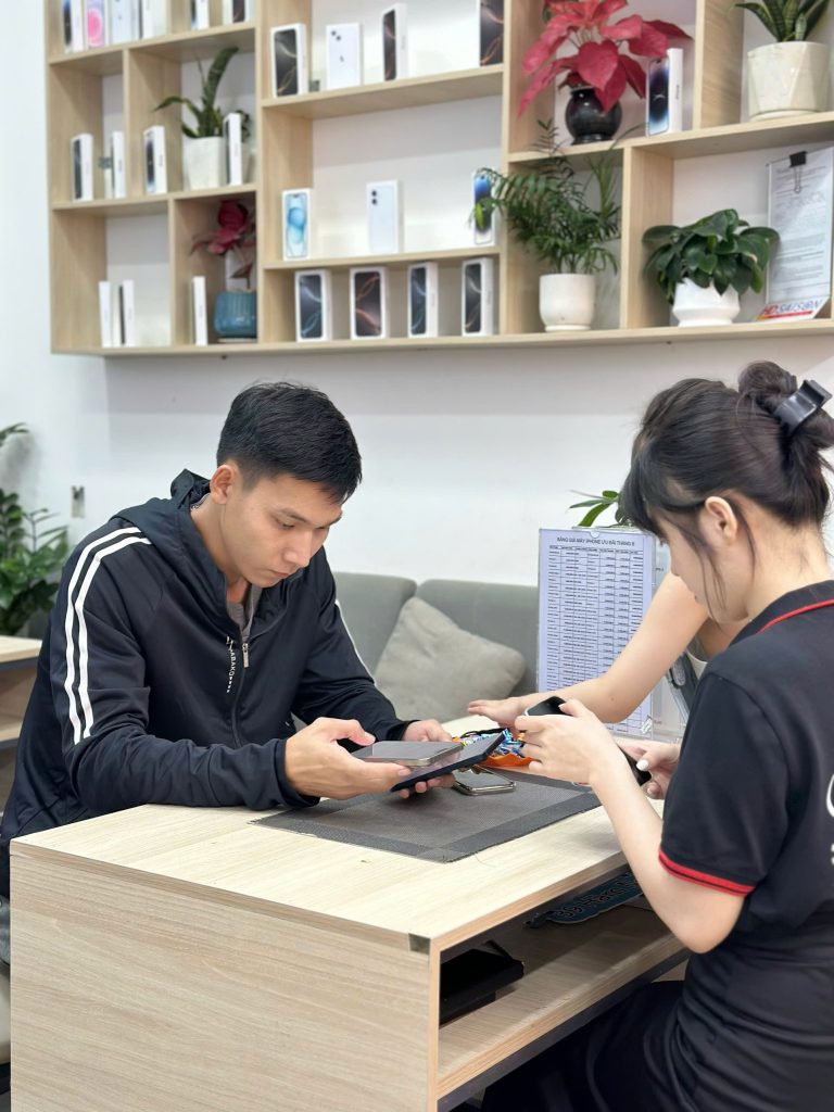 Khách hàng kiểm tra iPhone cũ tại cửa hàng Táo 247 Đà Nẵng trước khi nhận máy
