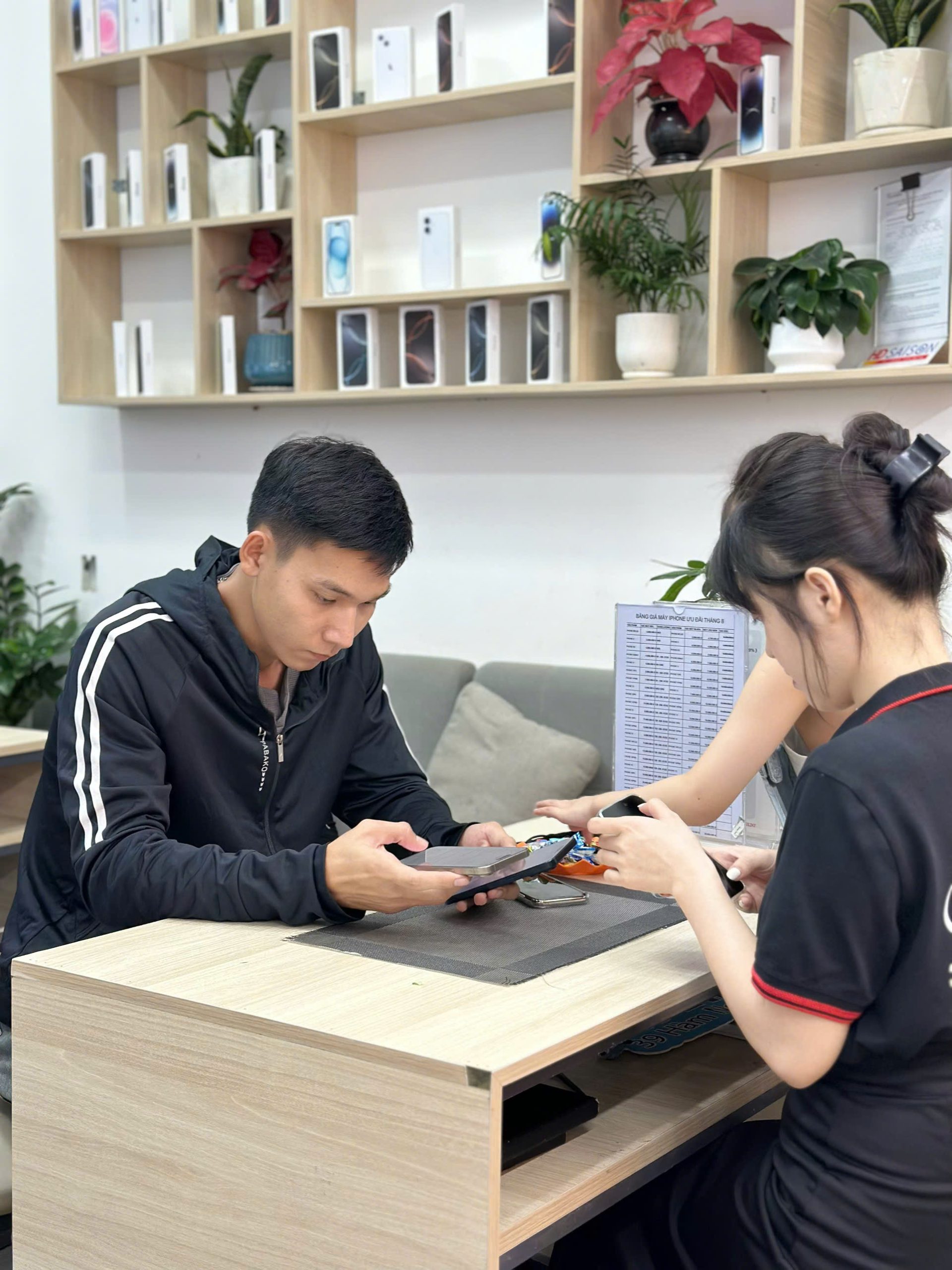 Khách hàng kiểm tra iPhone cũ tại cửa hàng Táo 247 Đà Nẵng trước khi nhận máy