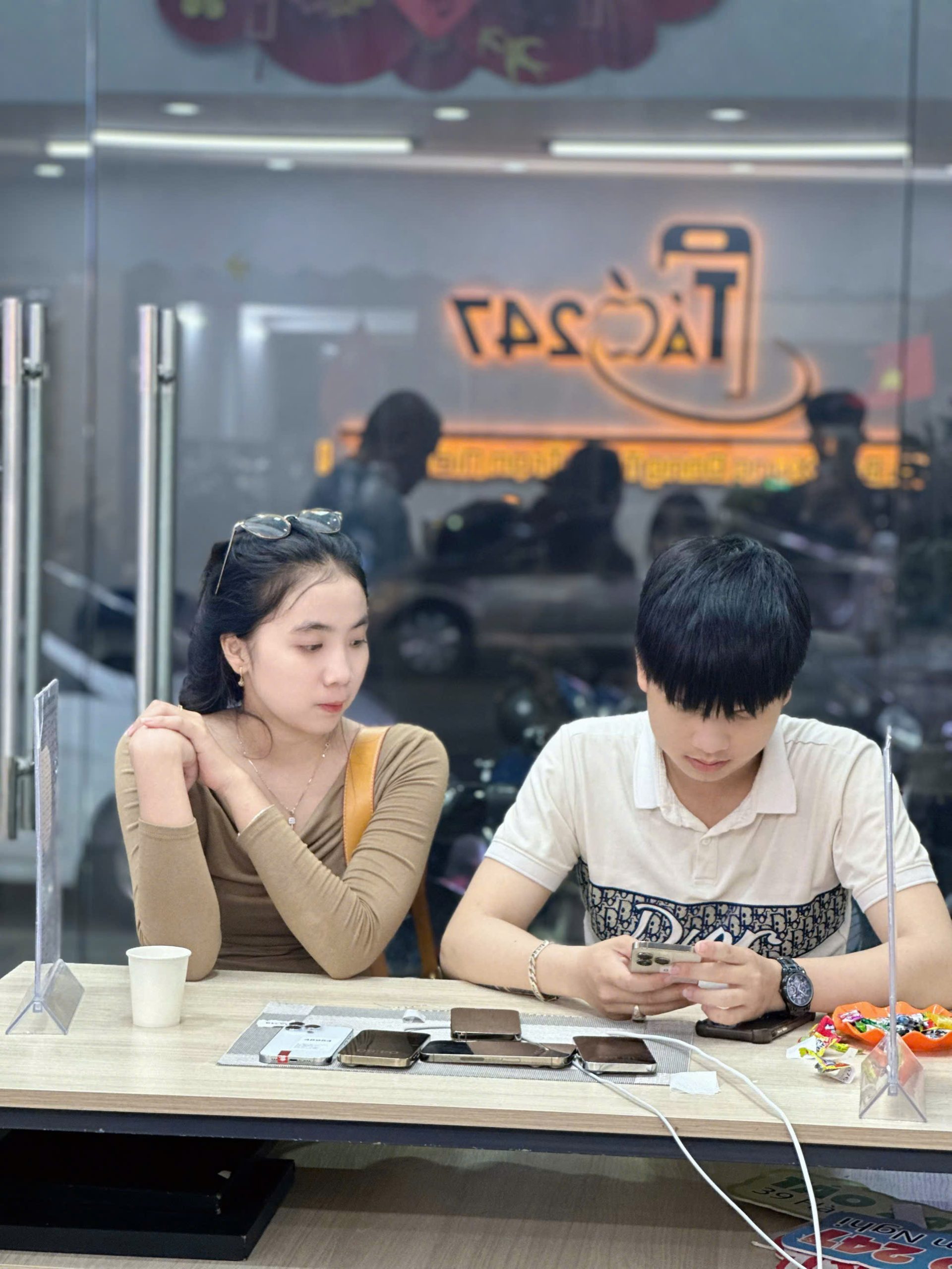 Khách hàng trẻ kiểm tra iPhone cũ tại cửa hàng Táo 247 Đà Nẵng