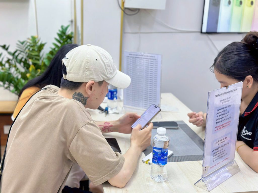 Khách hàng kiểm tra iPhone cũ tại Táo 247 Đà Nẵng, được tư vấn kỹ trước khi mua