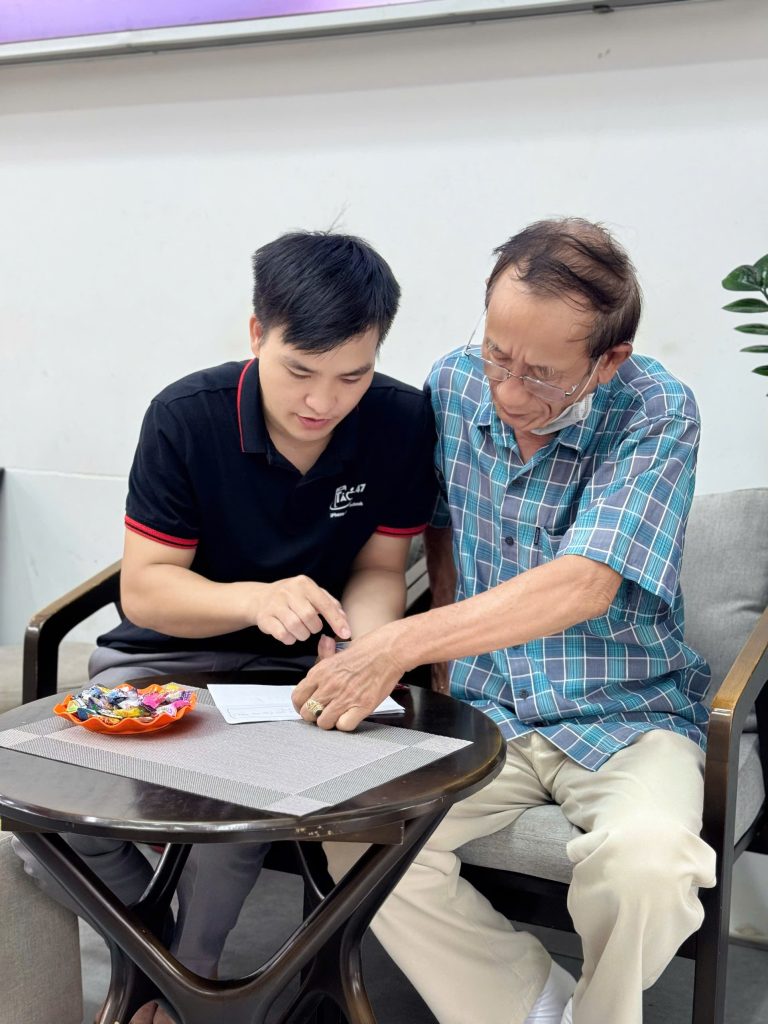 Nhân viên Táo 247 hướng dẫn khách hàng lớn tuổi làm hồ sơ mua iPhone trả góp tại Đà Nẵng