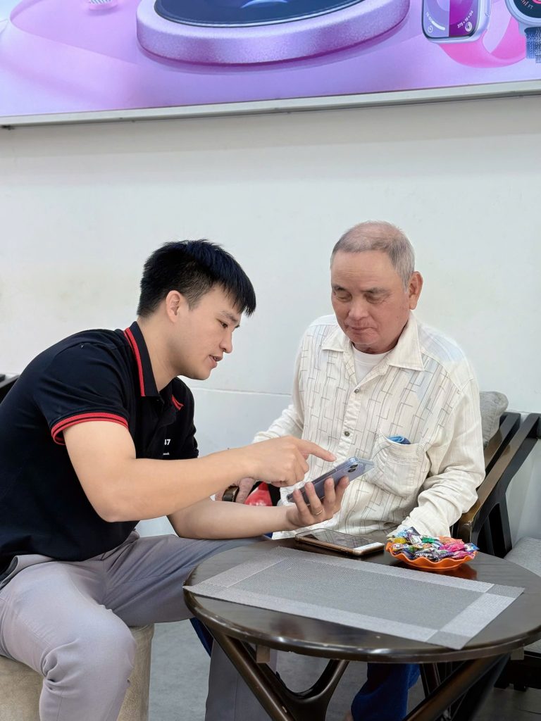 Nhân viên Táo 247 hướng dẫn khách lớn tuổi sử dụng iPhone cũ tại Đà Nẵng
