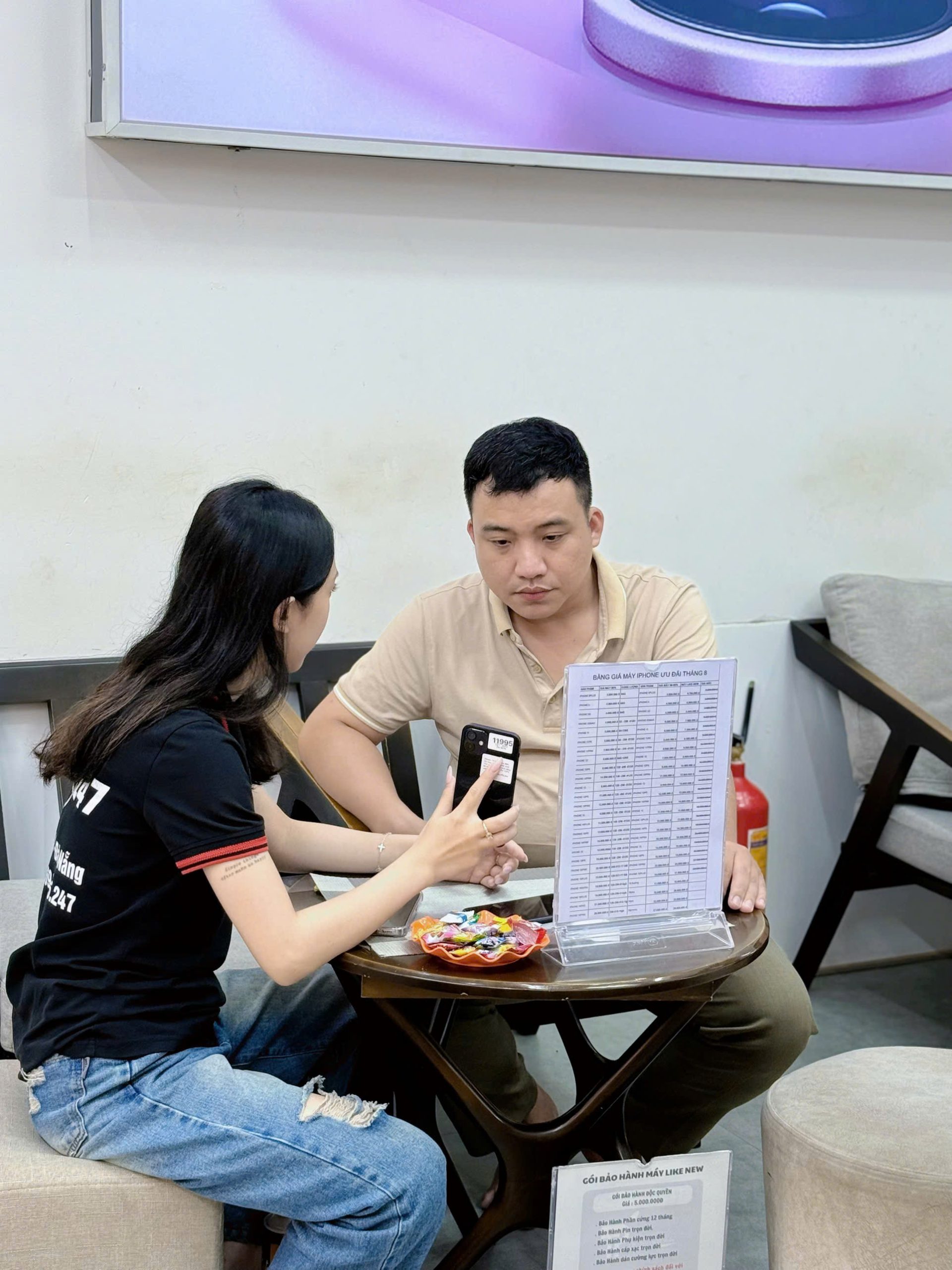 Khách hàng được nhân viên Táo 247 tư vấn bảng giá iPhone cũ Đà Nẵng 2025 tại cửa hàng