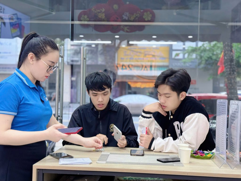 Nhân viên Táo 247 hỗ trợ khách hàng kiểm tra iPhone cũ trước khi mua tại Đà Nẵng

