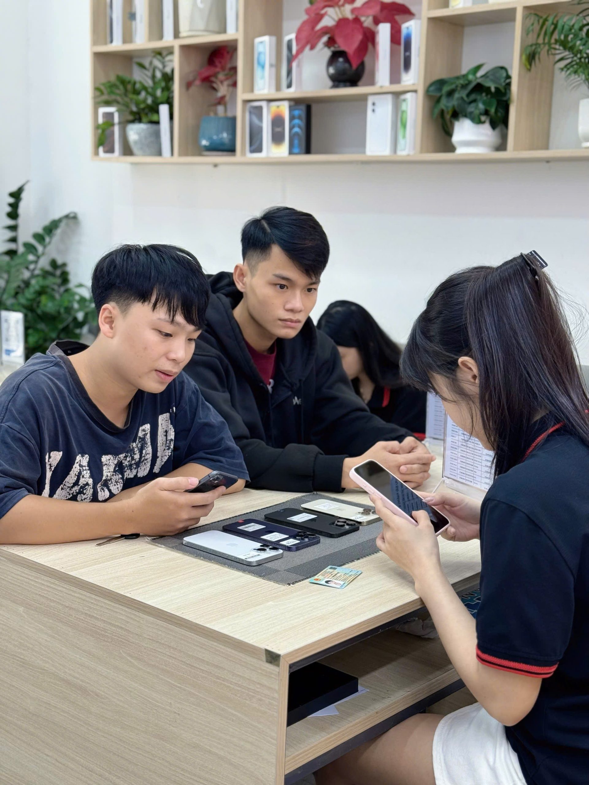 Khách hàng test iPhone cũ cùng nhân viên kỹ thuật tại Táo 247 Đà Nẵng