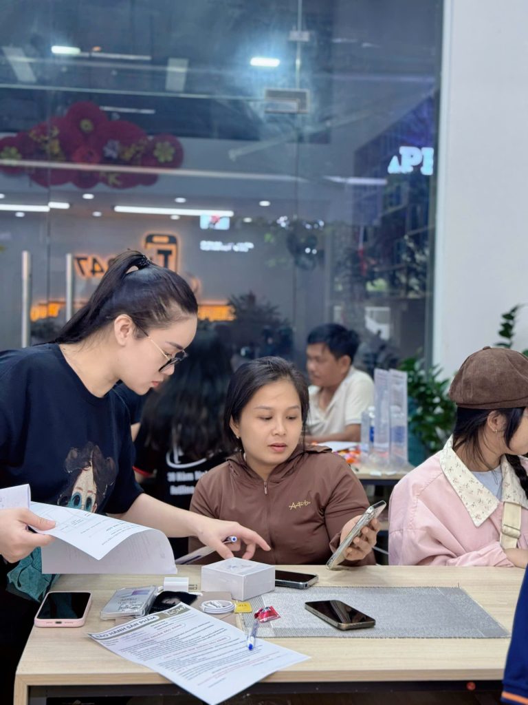 Khách hàng kiểm tra iPhone cũ tại Táo 247 Đà Nẵng cùng nhân viên tư vấn
