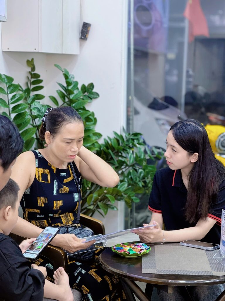 Nhân viên Táo 247 tư vấn iPhone cũ cho khách hàng lớn tuổi tại cửa hàng Đà Nẵng
