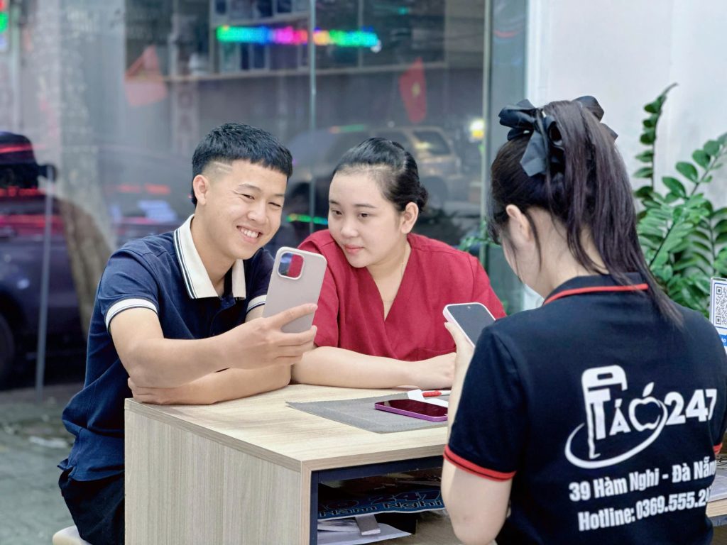 Khách hàng nhận iPhone mới tại cửa hàng Táo 247 Đà Nẵng với nụ cười hài lòng