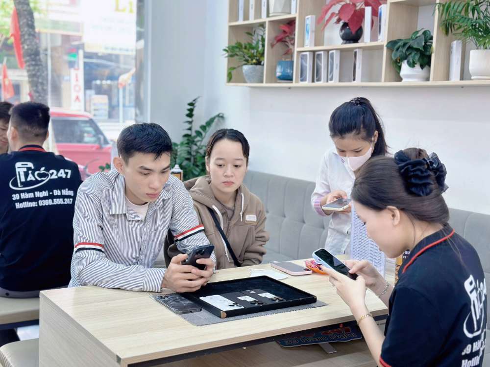 Khách hàng tại Táo 247 Hồ Chí Minh được nhân viên hỗ trợ test iPhone trước khi nhận máy – đảm bảo máy zin 100%, trả góp dễ dàng